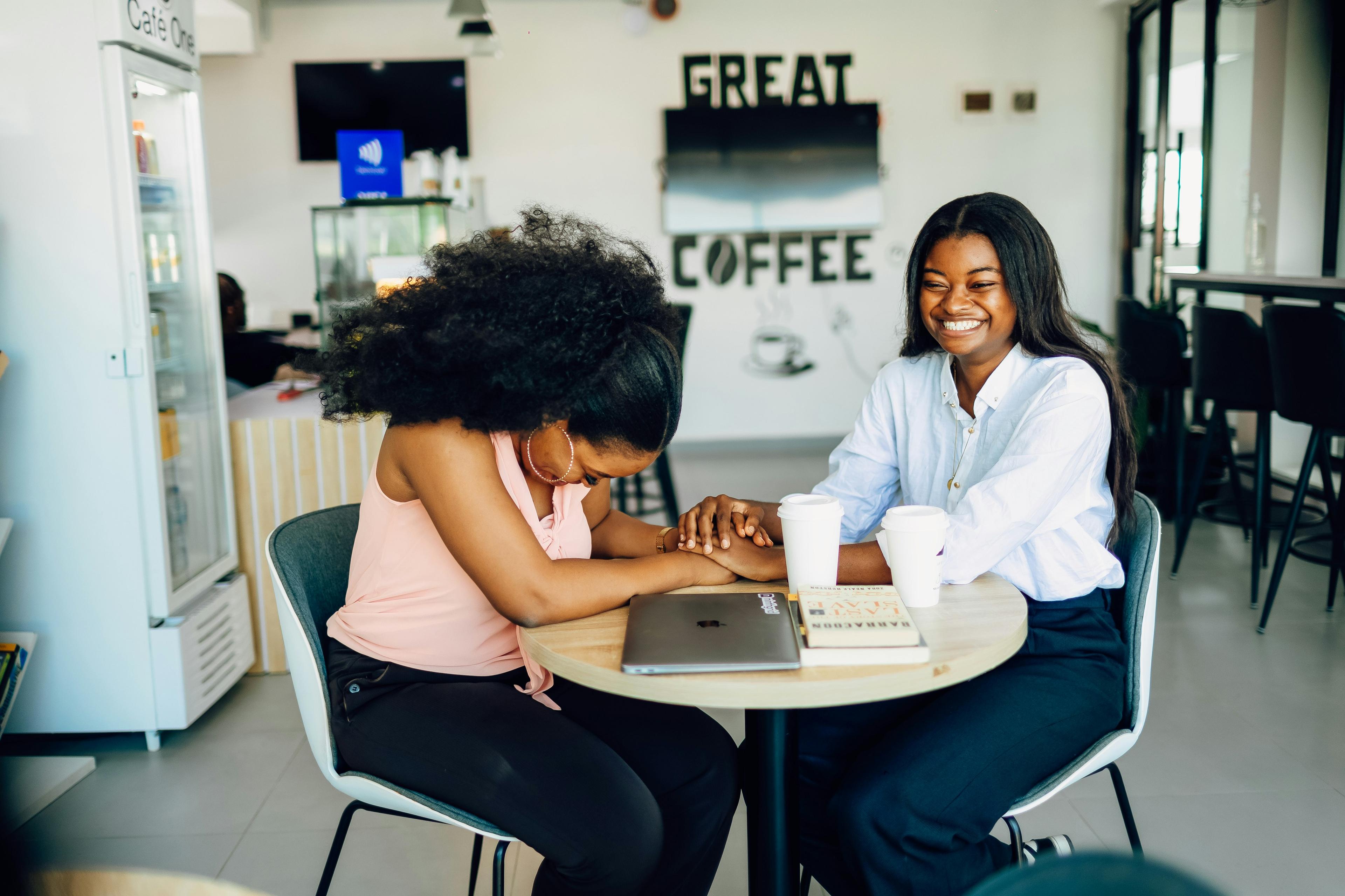 Two advisers in discussion over a report and coffee in an office lounge
